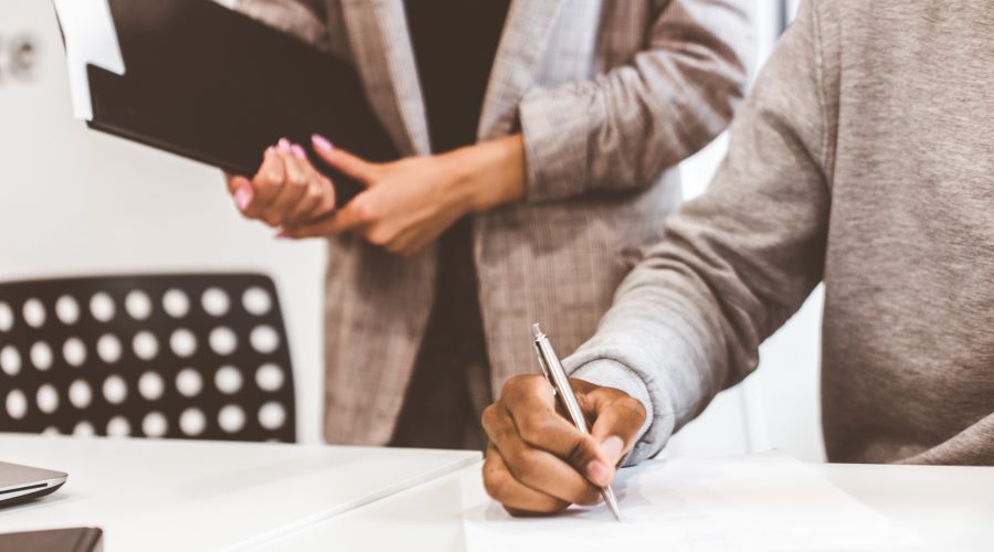 Man signing contract, black man hand putting signature on official document, biracial clients customers couple make purchase or sign prenuptial agreement concept