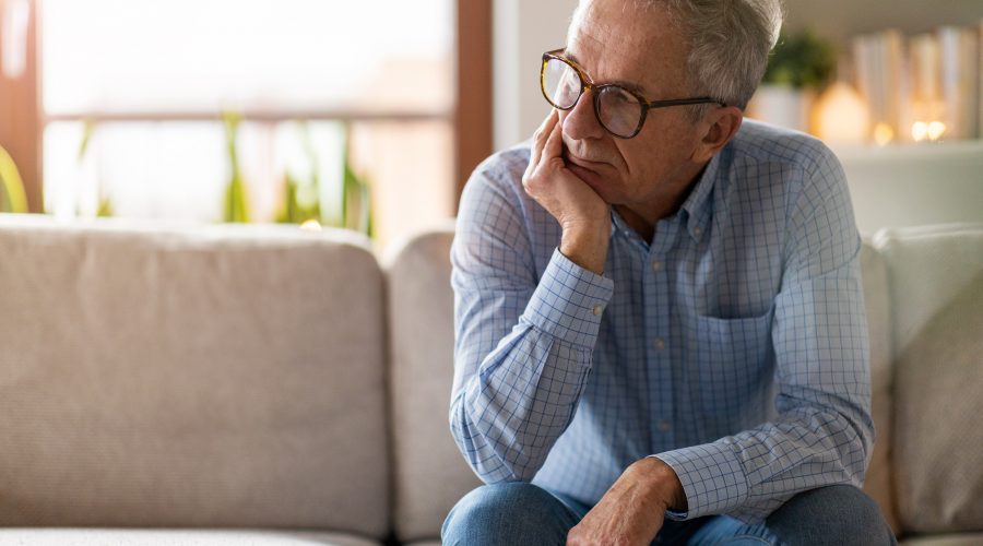 Senior man sitting alone in his home